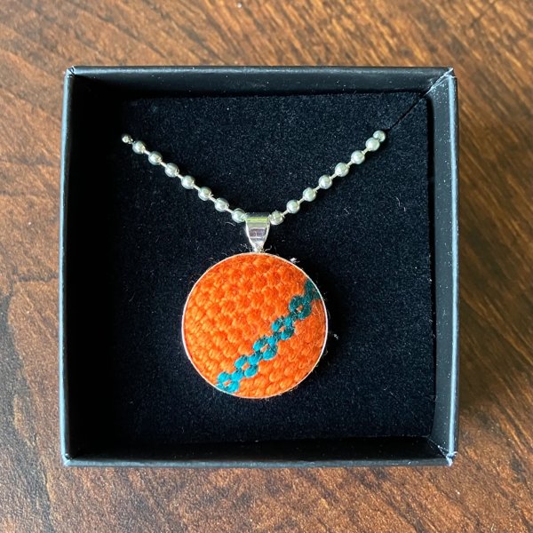 Product image of  Kudottu kaulakoru, oranssi petroolilla kuviolla