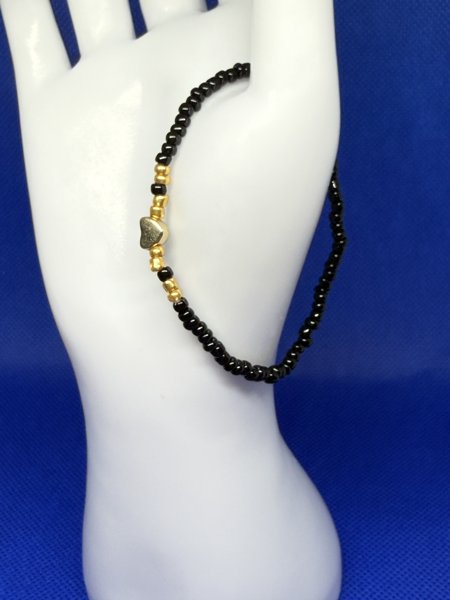 Product image of  🖤 Tyylikäs musta helmiranneke kultasydämellä